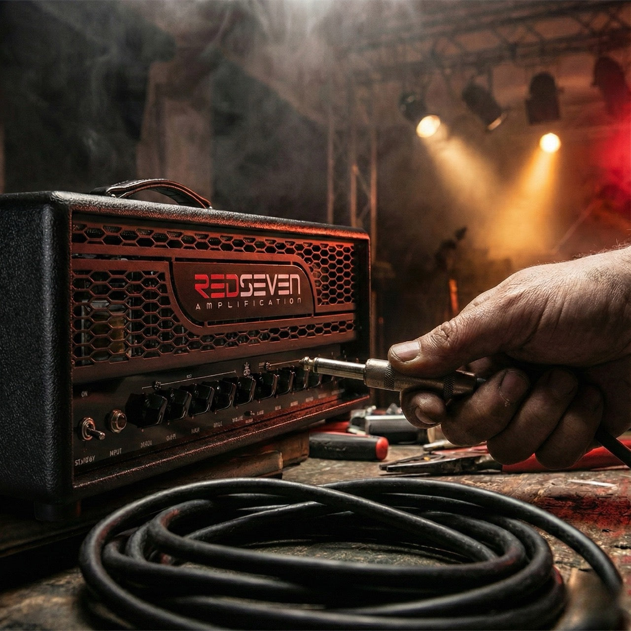 Rock-metal inspired atmospheric scene with glowing vacuum tubes, stage lights and musician’s hand gripping a jack cable — RedSeven Amplification